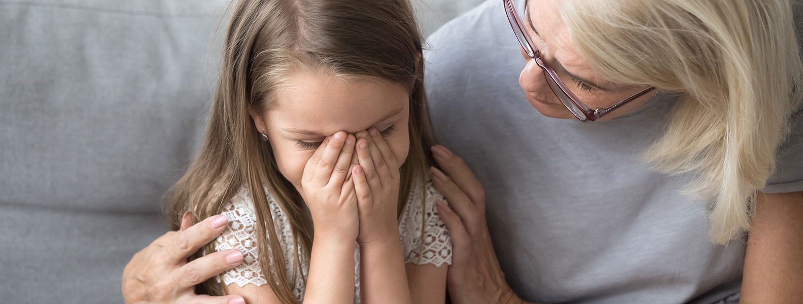 child crying with care giver